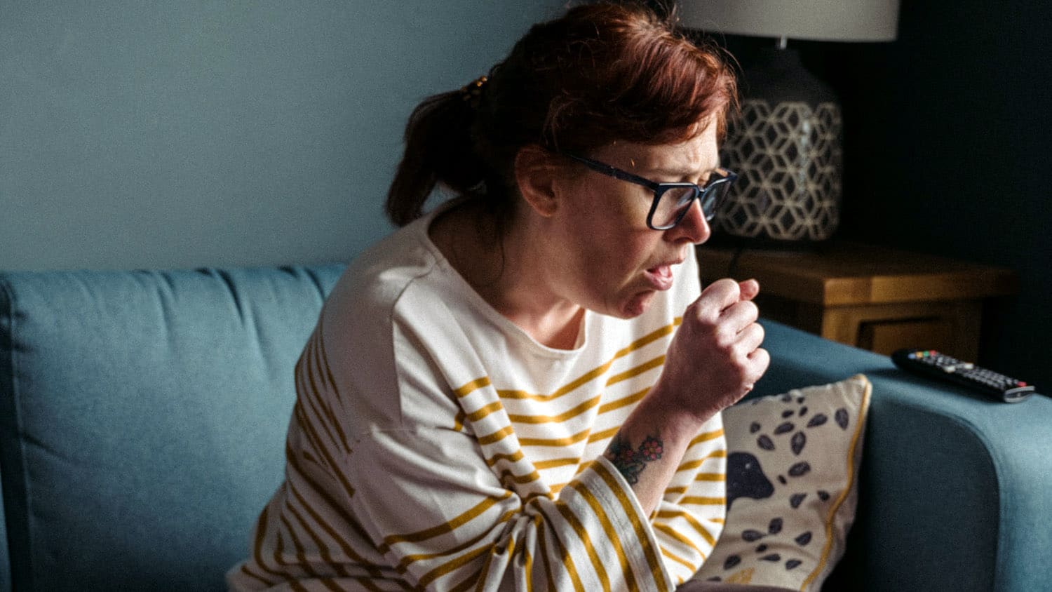 woman coughs into her hand